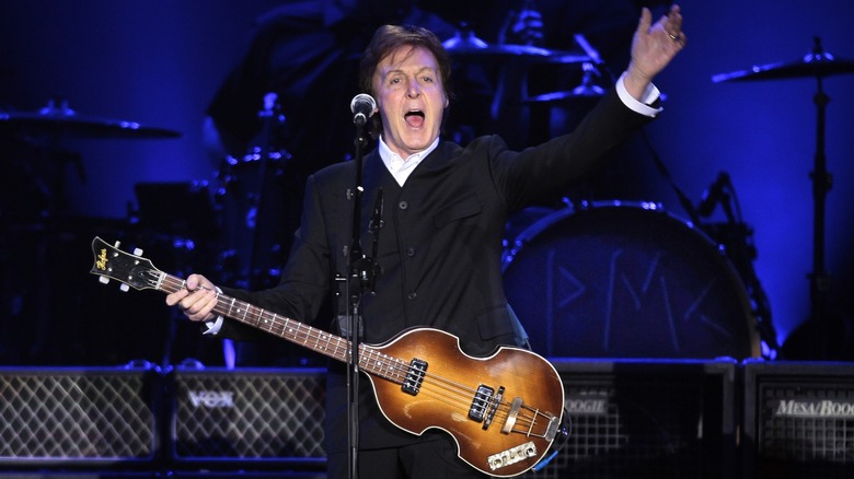 Paul McCartney onstage playing bass singing
