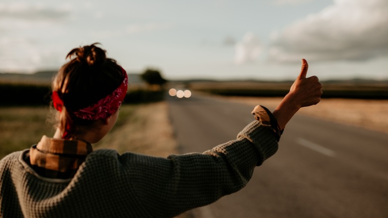 Woman hitchhiking on roadside