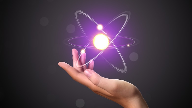 Rendering of human hand holding an atom