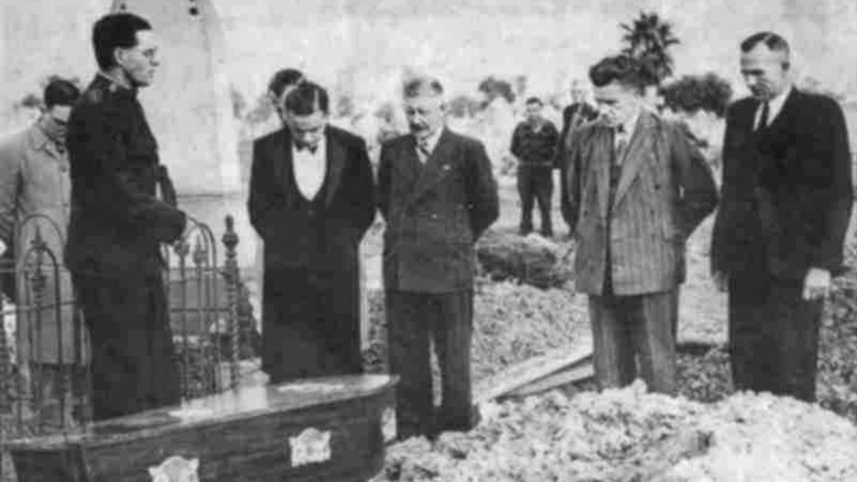 Burial of the Somerton Man on 14 June 1949. By his grave site is Salvation Army Captain Em Webb, leading the prayers, attended by reporters and police. From left to right are: Unknown, Captain Em Webb, Laurie Elliot, Bob Whitington, Unknown, S. C. Brice, police sergeant Scan Sutherland, Claude Trevelion.
