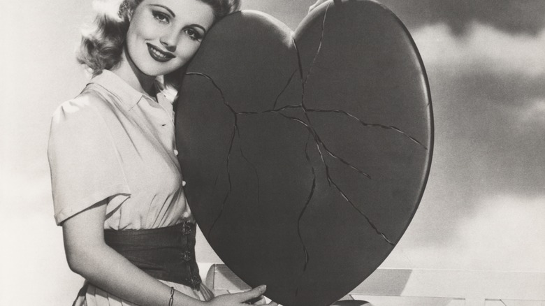 retro woman holding cracked heart 