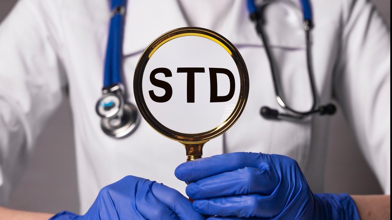 Doctor holding microscope with STD inside