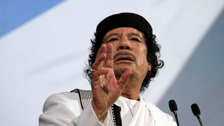 Muammar Gaddafi speaking microphone with raised hand