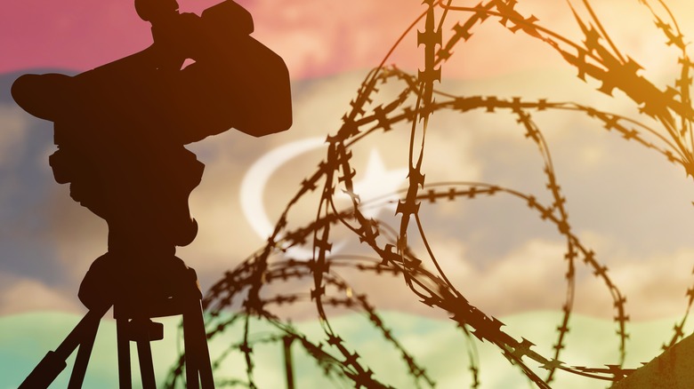 Video camera with barbed wire, red sky