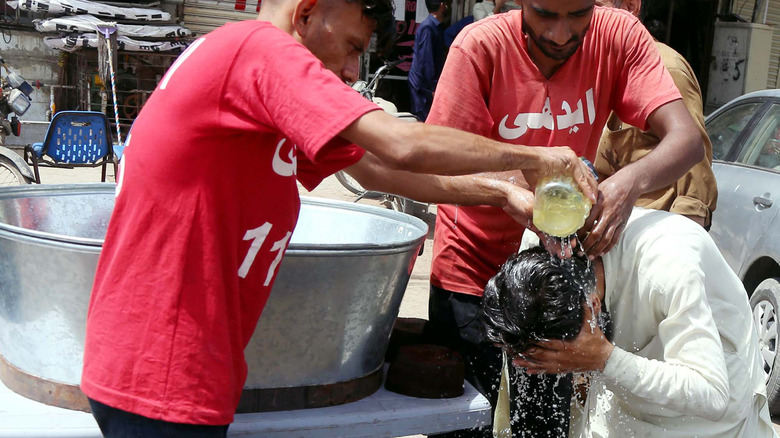 Volunteers pouring water on commuters in Karachi, Pakistan