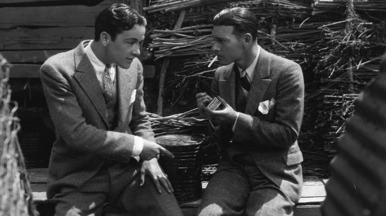 Two male actors relaxing and smoking on the set of "Wings"