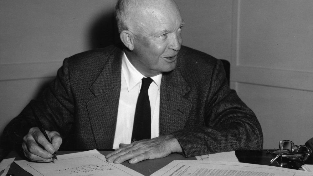 President Eisenhower signs a document.
