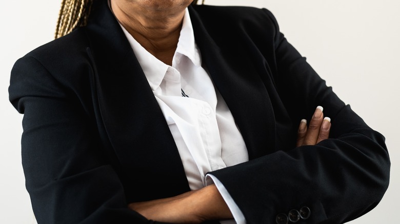 Black woman in suit with arms crossed