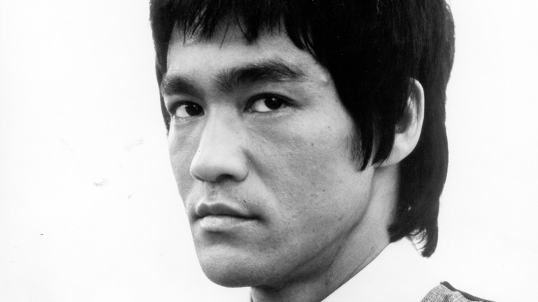 Suited Bruce Lee shirt looking sideways white background