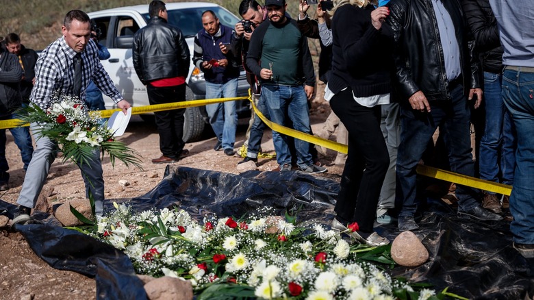 Man placing flowers on memorial