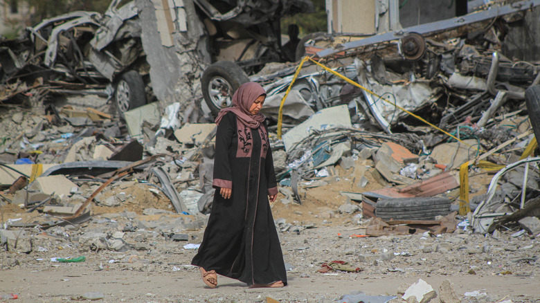 Woman walking amid rubble in Gaza 