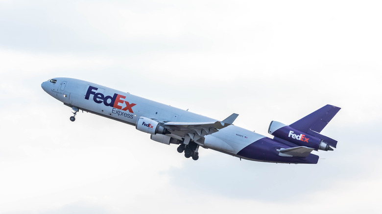 FedEx plane taking off white sky