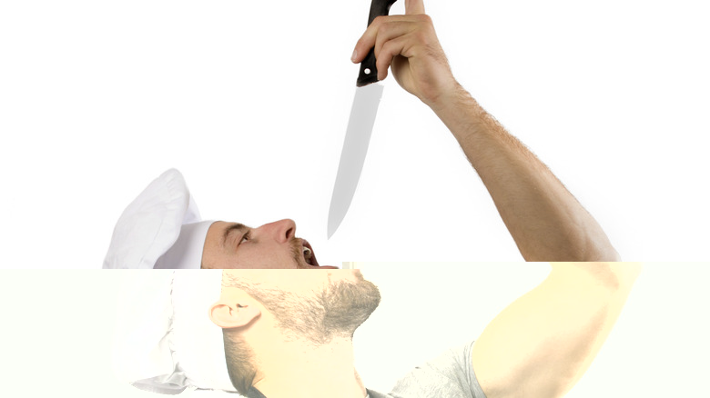 man holding knife above open mouth