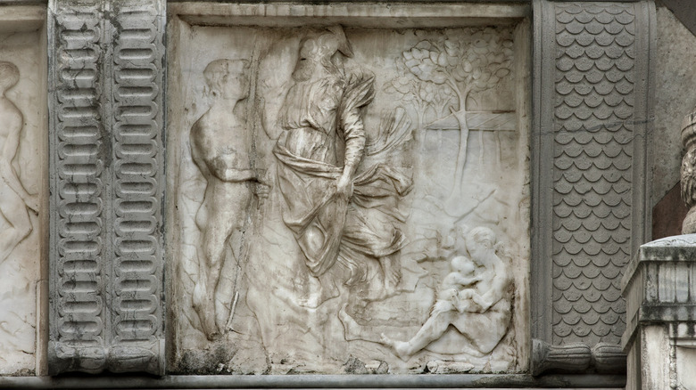 relief sculpture of adam, god, and eve with baby