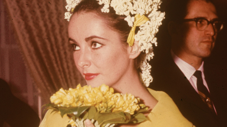 Elizabeth Taylor clutching wedding bouquet