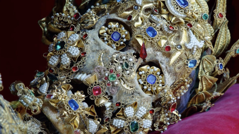 jeweled skeleton deluged in precious stones and metals