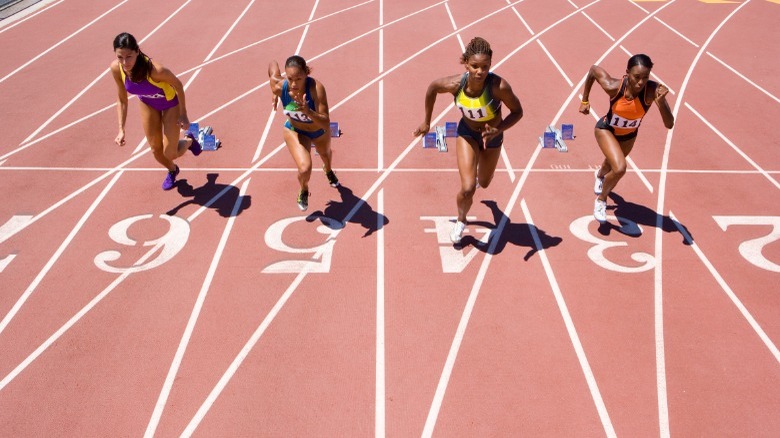 female athletes running on track 