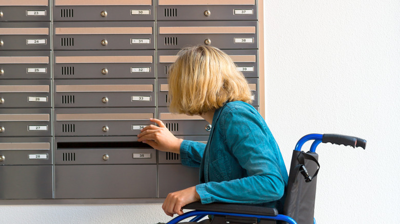 Woman in wheelchair checking mailbox