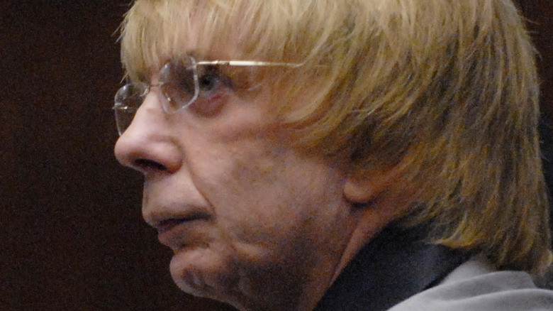 Phil Spector looking to side glasses