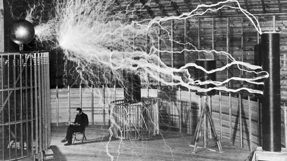 Nikola Tesla with a large electrical device in his laboratory