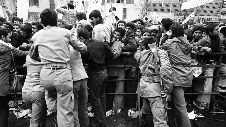 Revolutionary Guards try to hold back enthusiastic supporters of the hostage-takers in front of the U.S. embassy in December 1979
