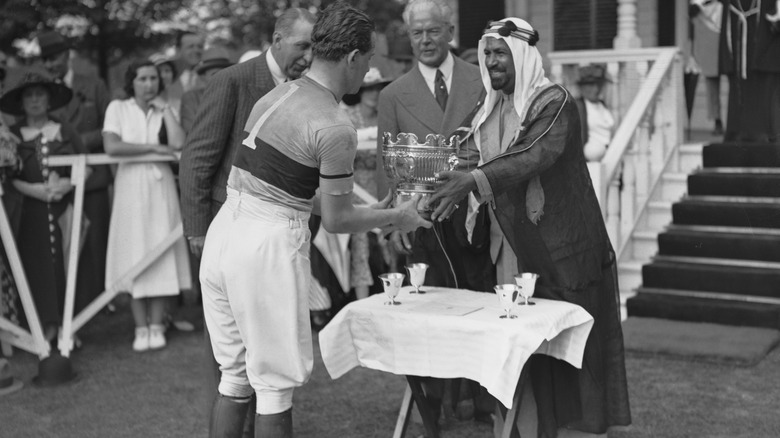 Alexis Mdivani receiving a polo trophy from a Sheikh