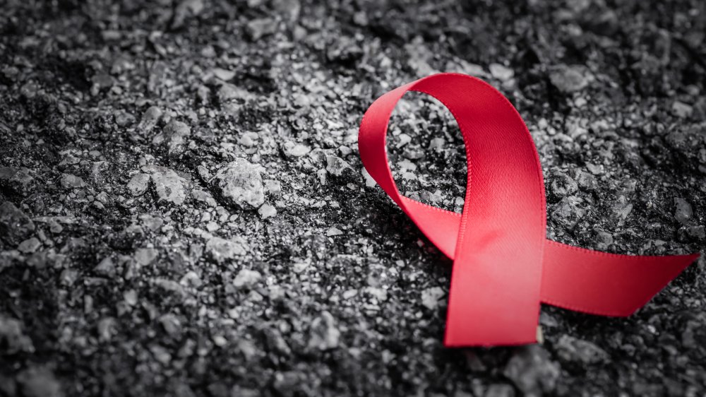 Red ribbon awareness on dark background for World Aids day campaign.