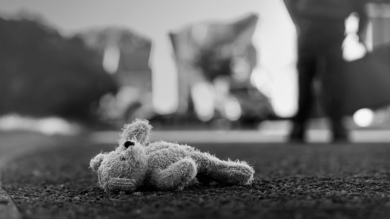A black and white picture of an abandoned teddy bear