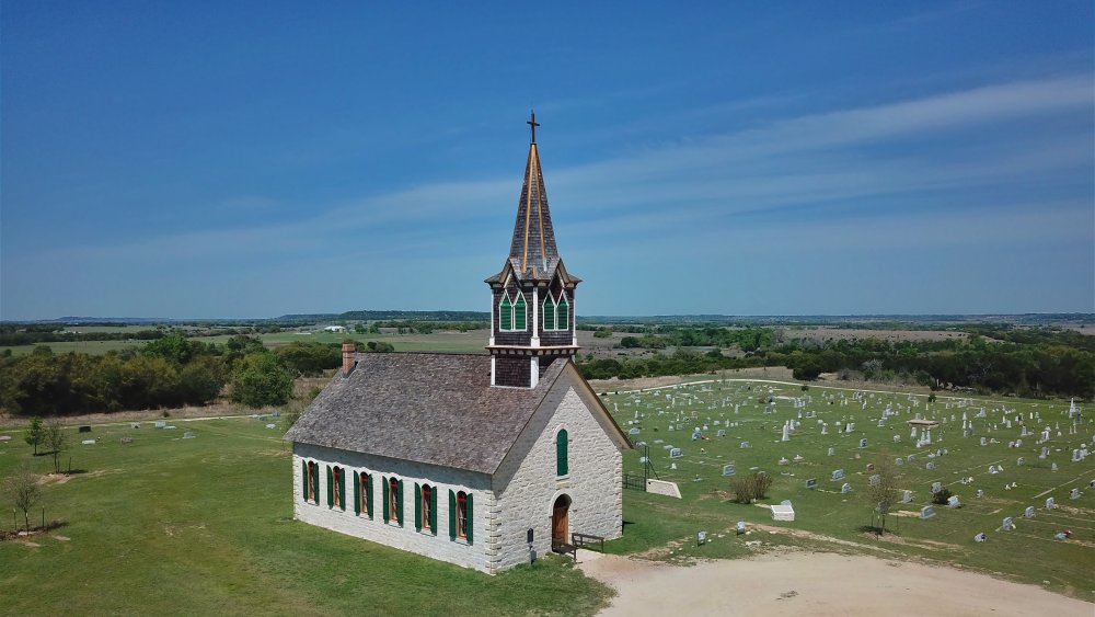 Old white stone church with graves near Waco, TX