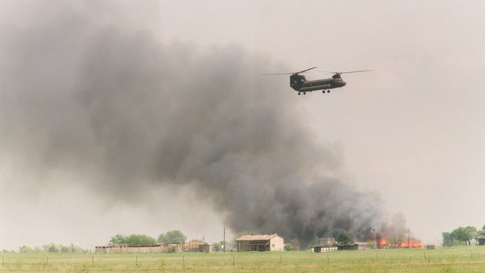 National Guard helicopter flies over burning buildings