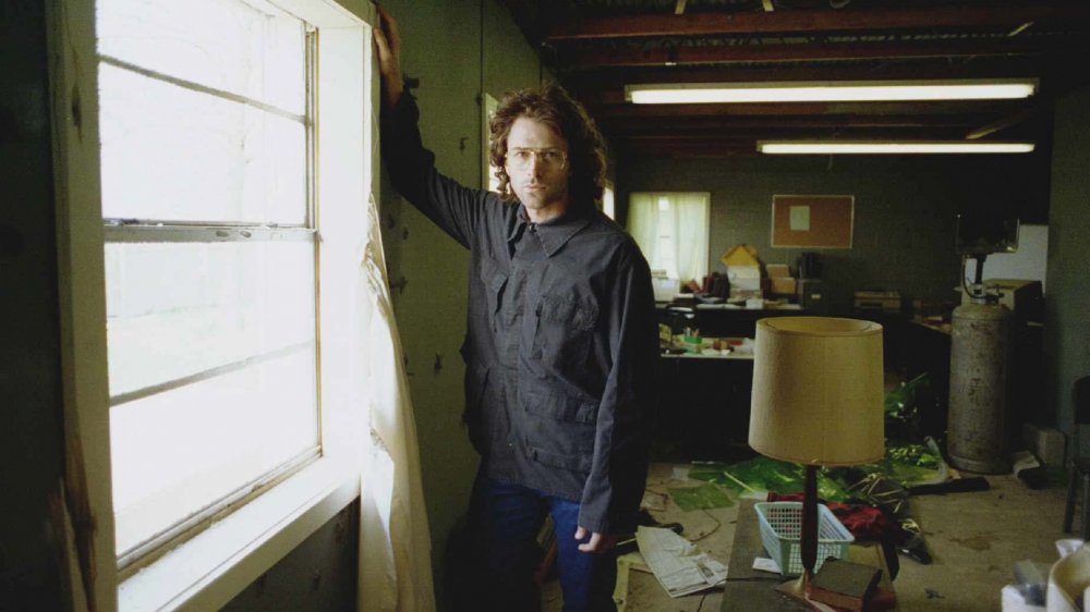 Tim Daly as David Koresh stands by a window
