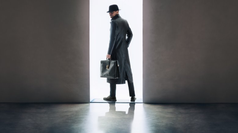 Spy black overcoat briefcase