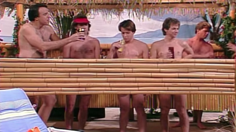 Five shirtless men behind bamboo screen