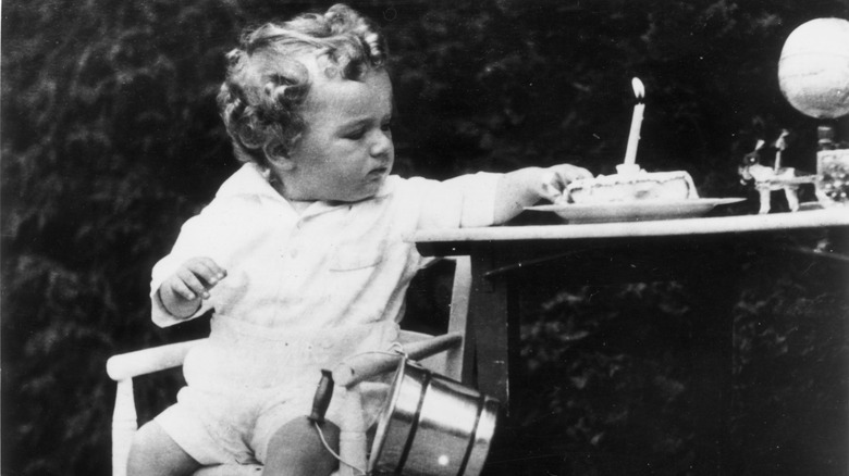 Charles Lindbergh Jr sitting with birthday cake with candle