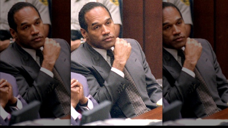 OJ Simpson sitting and listening in gray suit