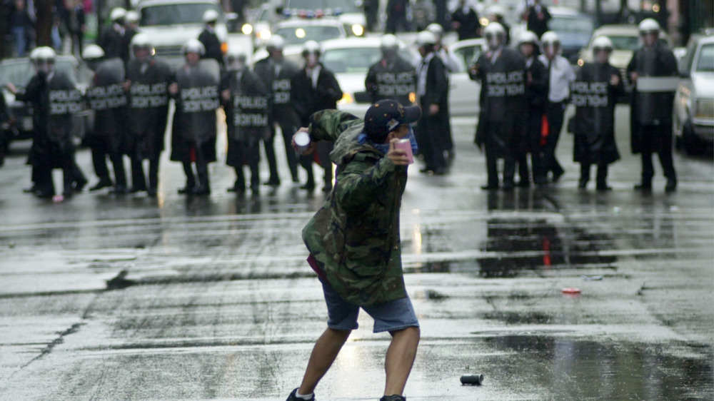 protester throwing garbage at police