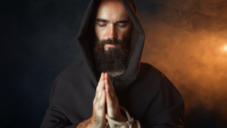monk in hooded robe praying