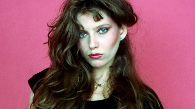 Bebe Buell looking sultry with a pink background in 1980