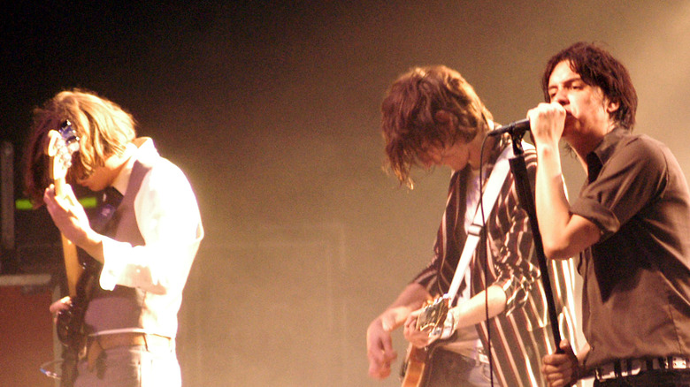 The Strokes on stage mics and guitars backlit