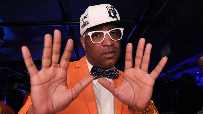 Marley Marl holding up hands white hat and glasses