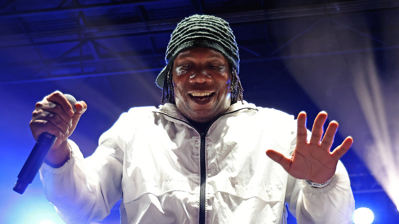KRS-One performing white jacket mic hat