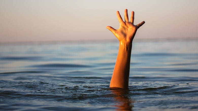 Drowning man reaching out of water