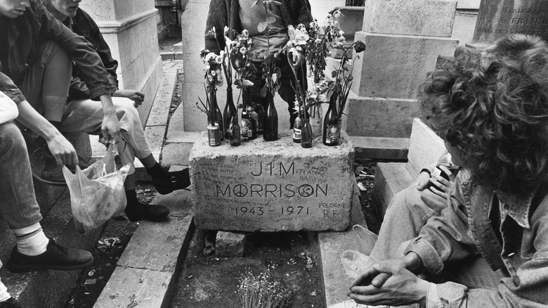 Jim Morrison gravestone with flowers and mourners