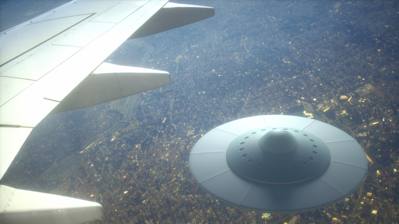 Illustration of a flying saucer by an aircraft wing.