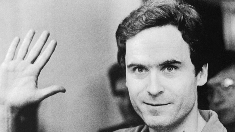Ted Bundy holding up one hand in court