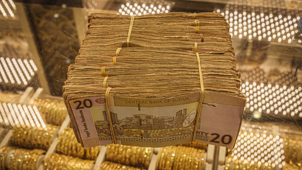 stack of gold and Sudanese money
