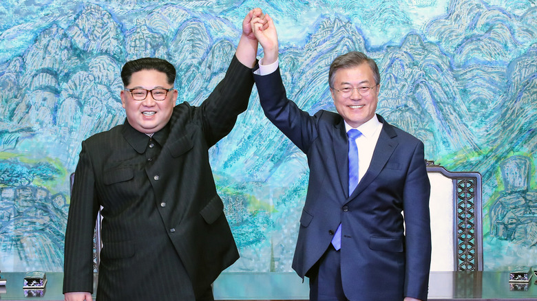 Kim Jong Un and South Korean President Moon Jae-in pose for photograph holding hands