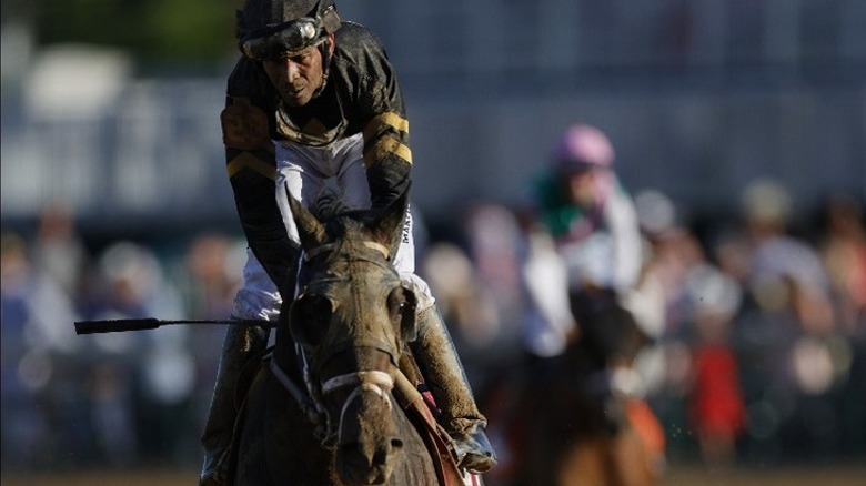 Kendrick Carmouche wearing jockey attire atop a racehorse