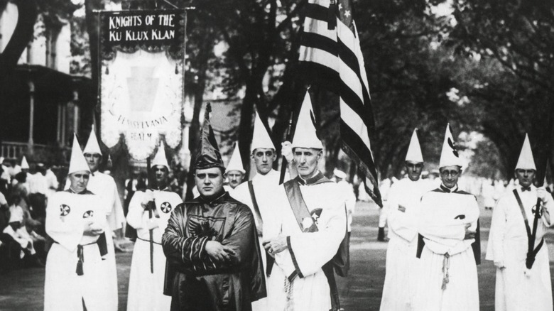 KKK rally men in robes with flags