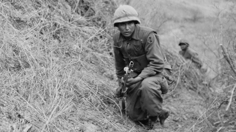 Soldier holding gun on hill